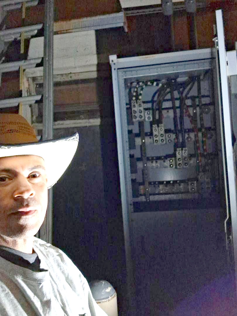 Cervantes Electric technician working an open breaker panel