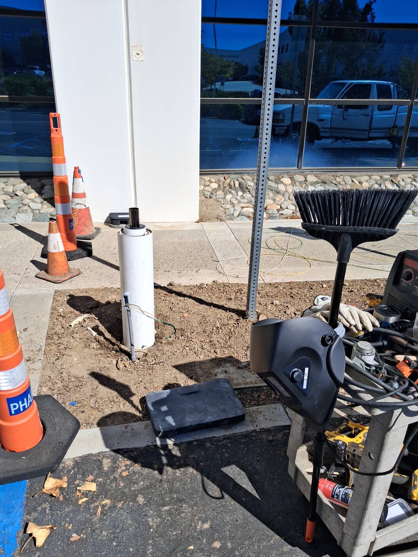 Outdoor commercial electrical job site with equipment and safety cones
